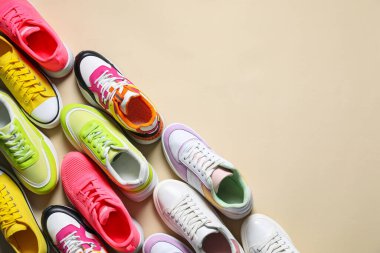 Spor ayakkabılar. Bej arka planda farklı spor ayakkabılar, düz yatış. Metin için boşluk