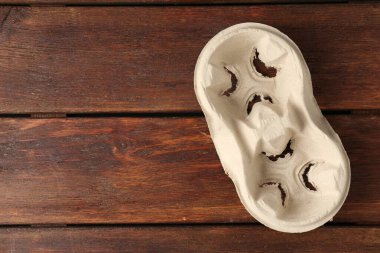 Empty cardboard cup holder on wooden table, top view. Space for text