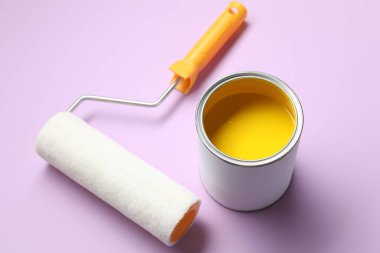 Mor arka planda sarı boya ve silindir kutusu