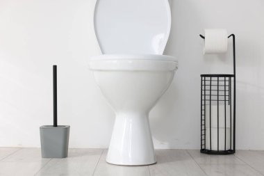 Beyaz duvarın yanında tuvalet, fırça ve ihtiyaçlar