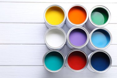 Beyaz ahşap masa üzerinde parlak boya kutuları, düz yatıyordu. Metin için boşluk