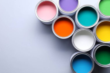 Gri arka planda parlak boya kutuları, düz bir zemin. Metin için boşluk