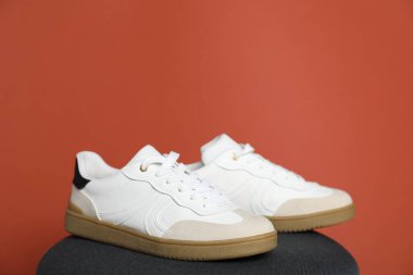 Kırmızı arka planda bir çift şık spor ayakkabı. Metin için boşluk