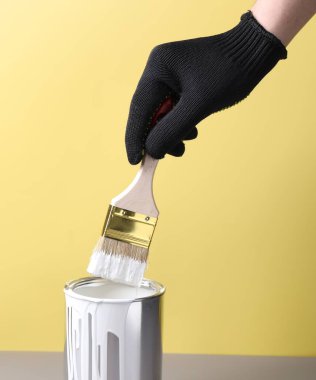 Renkli arka planda fırça ve beyaz boyalı adam, yakın plan