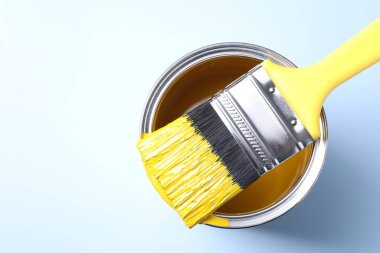 Arka planda sarı boya ve fırça kutusu, üst manzara. Metin için boşluk