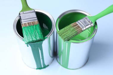 Açık arkaplanda boya ve fırça kutuları, yakın plan