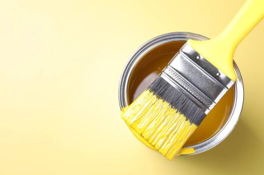 Sarı arka planda boya ve fırça kutusu, üst manzara. Metin için boşluk