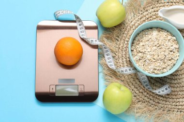 Elektronik mutfak ölçeği, mezura ve açık mavi zemin üzerindeki ürünler, düz zemin. Diyet
