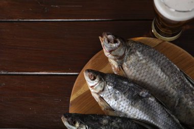 Lezzetli bira ve kurutulmuş hamamböceği balığı ahşap masada, düz yerde. Metin için boşluk