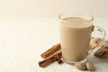 Cam bardakta Aromatik Masala çayı ve beyaz desenli masada baharatlar, yakın plan. Metin için boşluk