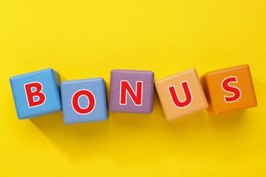 Sarı arkaplanda harflerle renklendirilmiş küplerden yapılmış kelime bonusu, üst görünüm