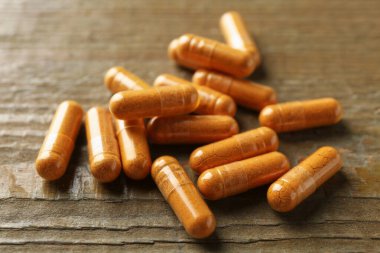 Tahta masanın üzerinde birçok zerdeçal kapsülü var.