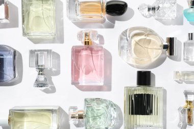 Farklı aromatik parfümler beyaz arka planda şişelerde, düz yerde