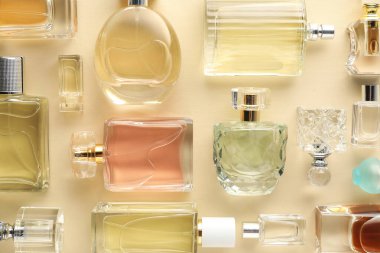 Bej arka planda çeşitli parfüm şişeleri, düzlük