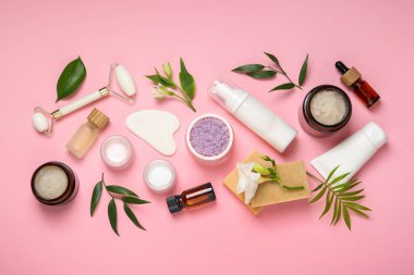 Pembe arka planda farklı vücut bakım ürünleriyle düz konum