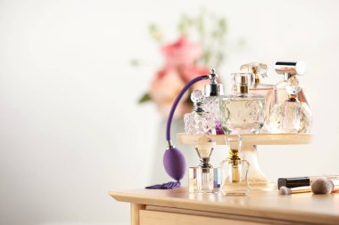 Odanın içinde ahşap tuvalet masasında farklı lüks parfümler, metin için yer.