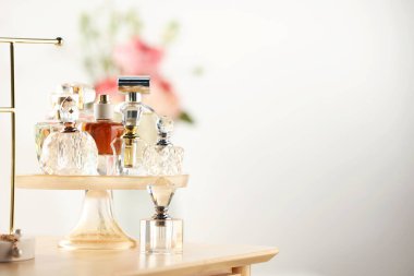 Odanın içinde ahşap tuvalet masasında farklı lüks parfümler, metin için yer.