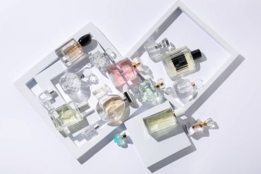 Beyaz arka planda farklı lüks parfümler, düz yatış