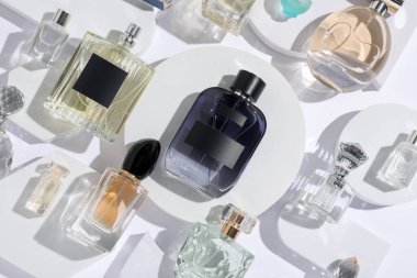 Beyaz arka planda farklı lüks parfümler, düz yatış