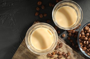 Bardakta kremalı kahve likörü ve siyah masada fasulye. Metin için boşluk