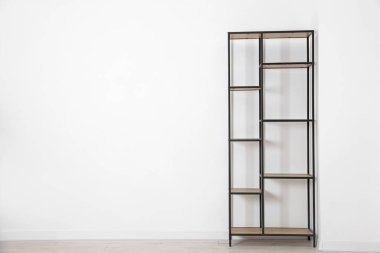 Empty shelving unit near white wall indoors, space for text