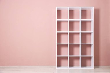 İçerideki pembe duvarın yanındaki boş raf ünitesi. Metin için boşluk