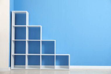 Açık mavi duvarın yanında boş raf ünitesi, metin için boşluk