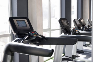 Spor salonundaki farklı koşu bantları. Spor malzemeleri.