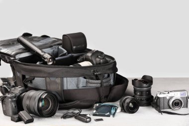 Profesyonel fotoğrafçı ekipmanı ve sırt çantası açık ahşap masada. Metin için boşluk