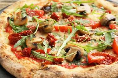 Mantarlı, domatesli ve roka soslu lezzetli pizza.