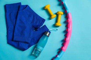 Different gym stuff on light blue background, flat lay