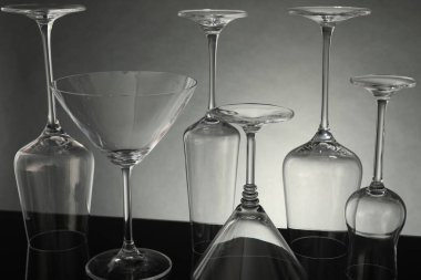 Gri arkaplana karşı ayna yüzeyinde birçok boş bardak