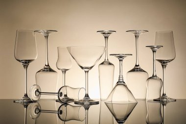 Ayna yüzeyinde bej arkaplana karşı birçok boş temiz bardak