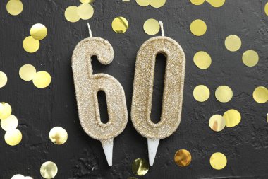 60. yaş günü. Siyah zemin üzerinde numara şekilli mumlar ve konfeti, düz uzanma