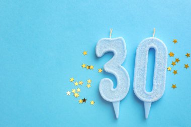 30. yaş günü. Açık mavi arkaplandaki mumlar ve konfetiler düzdü. Metin için boşluk