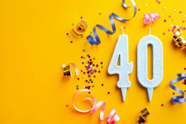 40. yaş günü. Numara şekilli mumlar ve turuncu arka planda parti dekorasyonu. Metin için boşluk