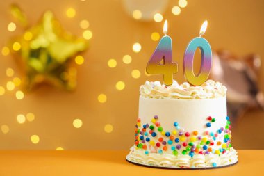 40. yaş günü. Masada yanan sayılı pasta bulanık arkaplan, ışıklar, yakın çekim ve metin için boşluk ile bulanık arkaplan şeklinde mumlar. Bokeh etkisi