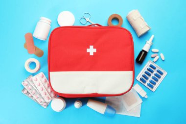 First aid kit. Different medical supplies on light blue background, flat lay