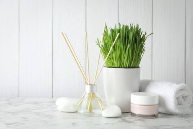 Beyaz masa üzerinde buğday çimi olan spa kompozisyonu