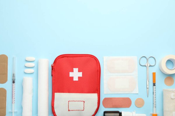 First aid kit. Different medical supplies on light blue background, flat lay. Space for text