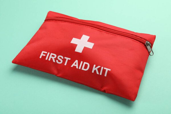 Комплект первой помощи на бирюзовом фоне, крупный план