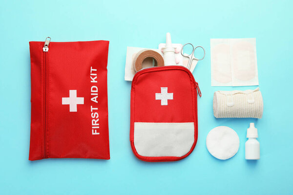 First aid kit. Different medical supplies on light blue background, flat lay