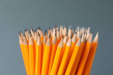 Gri arkaplanda birçok grafit kalem, yakın plan