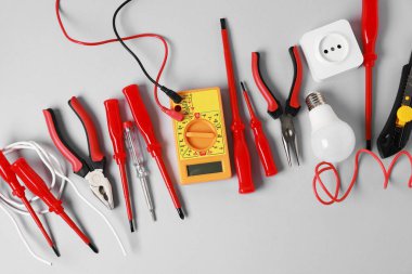 Different electrical tools on grey background, flat lay
