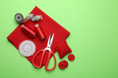 Yeşil arka planda farklı dikiş malzemeleri var. Metin için boşluk