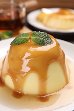 Karamel soslu lezzetli puding ve nane şekeri, yakın plan.