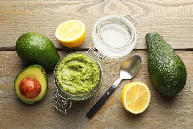 Lezzetli avokado sosu cam kavanoza, meyveler ahşap masaya.