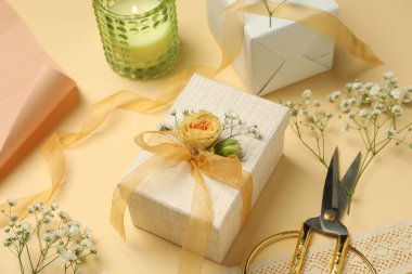 Çiçekçi. Bej arka planda kutular, çiçekler, kurdele ve makas, yakın plan