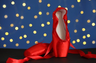 Bulanık ışıklara karşı siyah masada bir çift şık sivri ayakkabı.