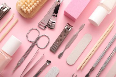 Pembe arka planda farklı manikür araçları, düz yatış